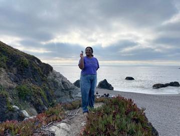 Picture of person on beach holding a flower.
