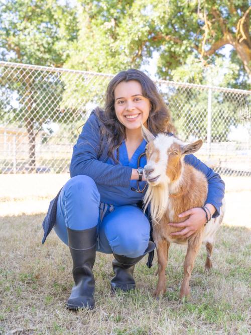 Person posing with a goat.