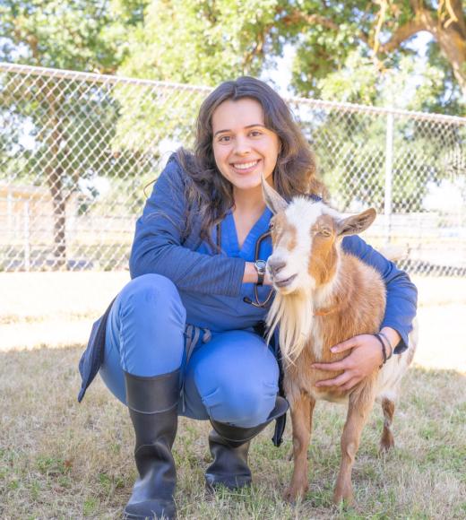Person posing with a goat.