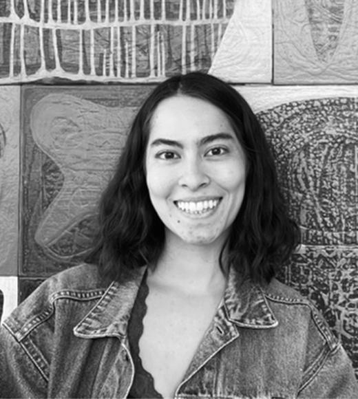 Person smiling in front of art.