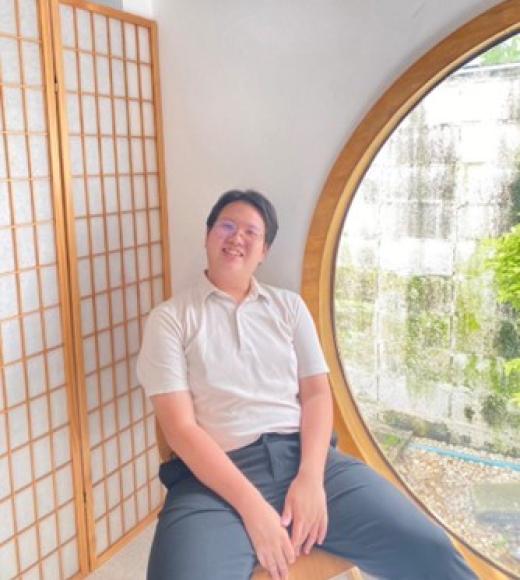 Person smiling in front of window.